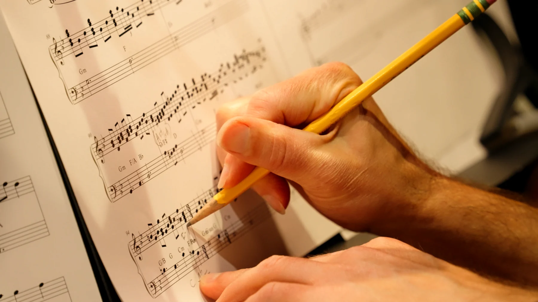 A musician annotating an orchestral score